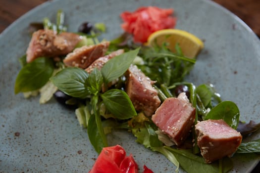 beautiful food: steak tuna in sesame, lime and fresh salad close-up on a plate on the table. horizontal