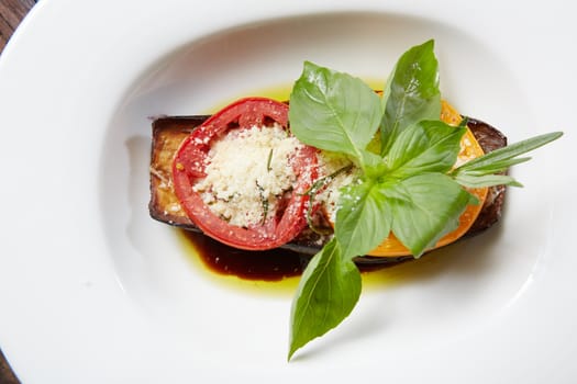 Baked eggplant with parmesan cheese, tomatoes and basil