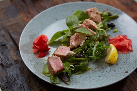 beautiful food: steak tuna in sesame, lime and fresh salad close-up on a plate on the table. horizontal