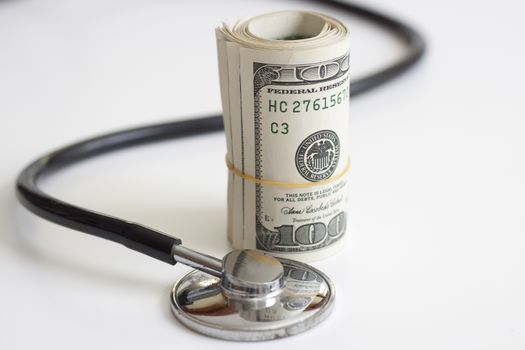 a stack of dollars and a stethoscope health insurance future