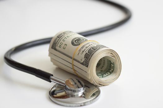 a stack of dollars and a stethoscope health insurance future