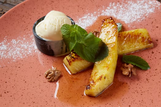 Grilled pineapple with scoops of vanilla ice cream