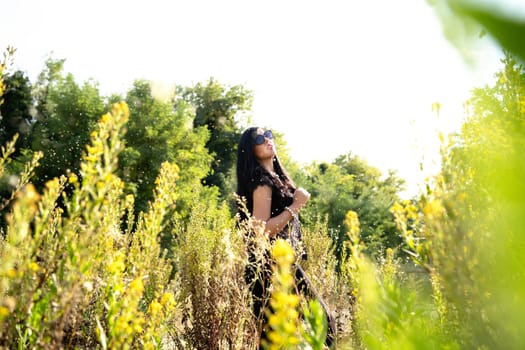 young beautiful fashion girl in yellow field wearing sunglasses