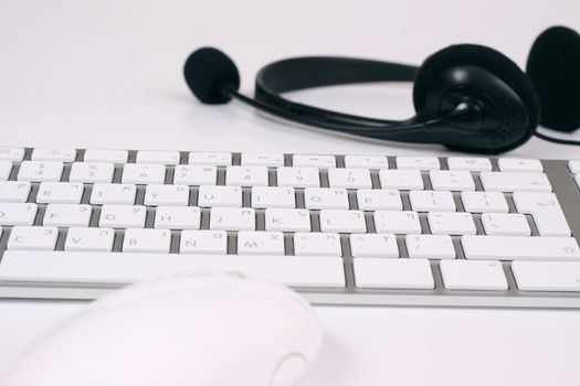 slim silver keyboard with mouse and headset on white background