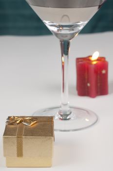 romantic proposal theme with a golden ring box a shampain glass and a red candle with flame