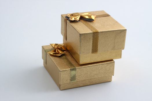 two goldem gift  ring boxes on top of each other