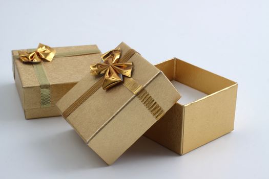 two goledn gift ring box one open empty inside on white background
