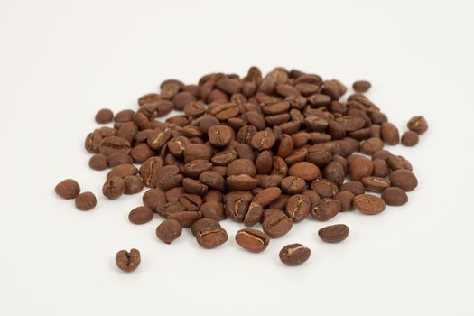 some brown roasted coffee beans on white background