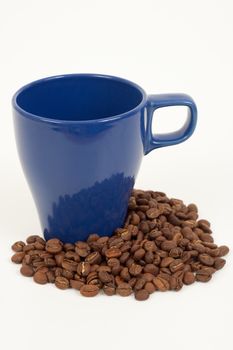 blue coffee cup with some coffee beans around