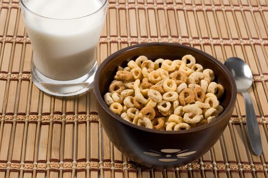 corn flakes in a bowl and a glass of milk
