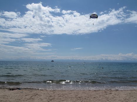the parachute descends into the sea and the beach is close and the ship is far away          