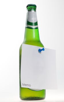green beer bottle with memo note and a pin