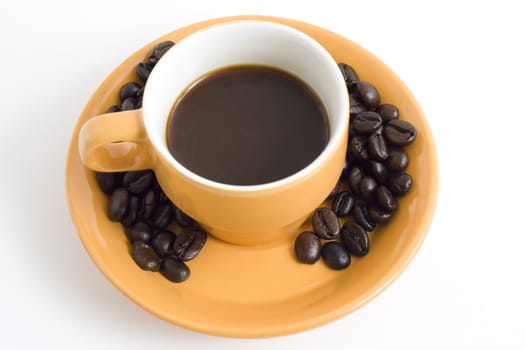 an oranje cup of coffe with coffee beans and a plate