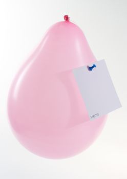 pink baloon with memo note attached with a pin