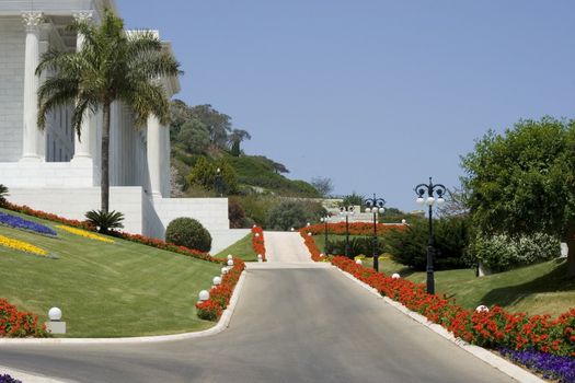 sidewalk in the garden colored flowers and blue sky