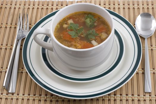 vegetable soup on plates with spoon fourk and knife