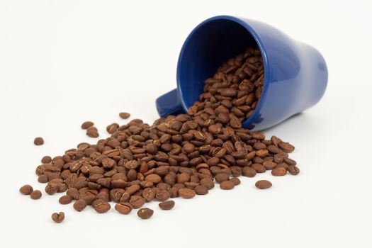 brown roasted coffe spelled off a blue coffee mug