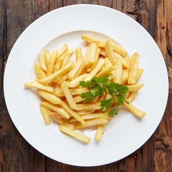 French fries in a bowl on a wooden background