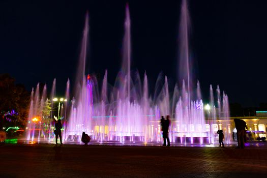 Bright colorful fountains at night on the embankment of the Amur river in the city of Khabarovsk. Bright color. Illumination of lanterns.