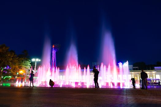 Bright colorful fountains at night on the embankment of the Amur river in the city of Khabarovsk. Bright color. Illumination of lanterns.