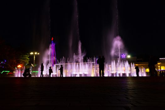 Bright colorful fountains at night on the embankment of the Amur river in the city of Khabarovsk. Bright color. Illumination of lanterns.