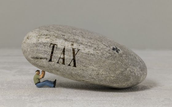 Tax concept, man collapses under the tax burden