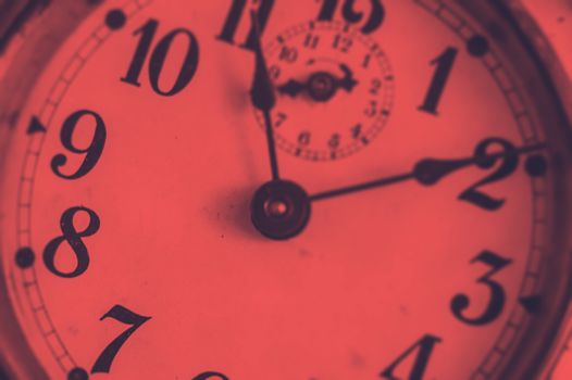 Detail of the hands of an ancient analogue clock with a duotone effect