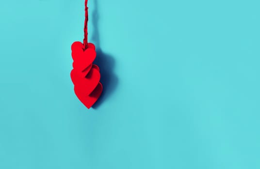 Group of red wooden hearts hanging with a duotone color effect