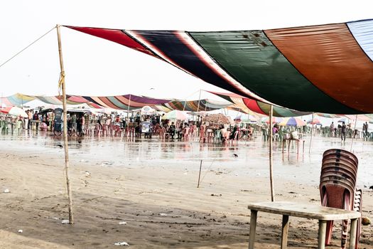 Versova beach, Mumbai India 10, Jan 2019: Beach market View of crowded with tourists and vendors in during new year festival, causes water pollution due to plastic and pile of garbage.