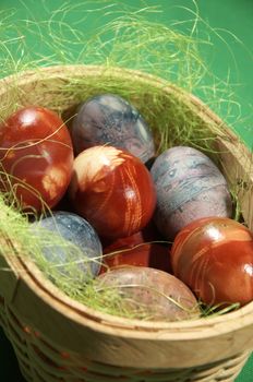 Painted eggs at Easter. Easter eggs in basket. Eggs in basket on green background.