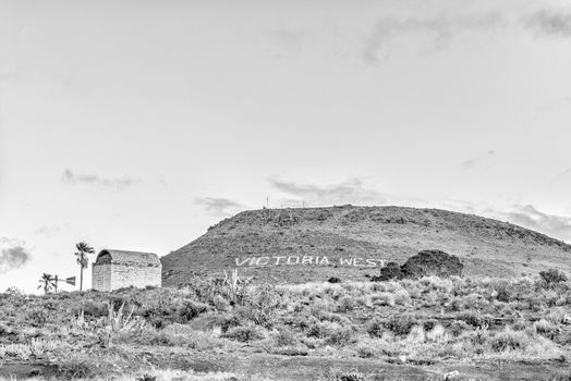 VICTORIA WEST, SOUTH AFRICA, AUGUST 7, 2018: An historic gunpowder magazine in Victoria West in the Northern Cape Province. The name of the town is visible in the back. Monochrome