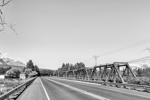 The road bridge and historic railway bridge over the Breede River at Wolseley in the Western Cape Province. The historic blockhouse is visible. Monochrome