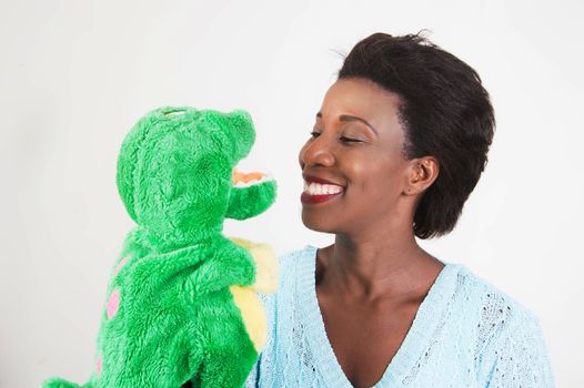 young woman draws attention to her child on the toy that fits in the hand.