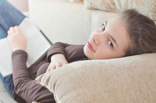 Close up of lying girl reading book relaxing at home