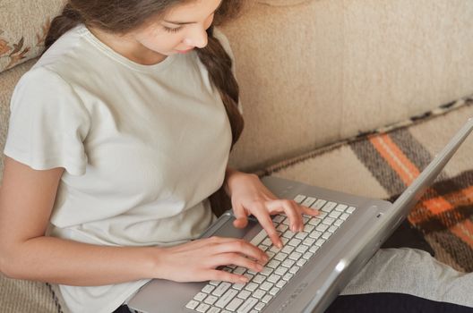 Young Cute Female Student Doing Homework in Bed. College Student Doing Homework in Bed at Home, Young Woman Preparing School Test in Bedroom. Education Concept.