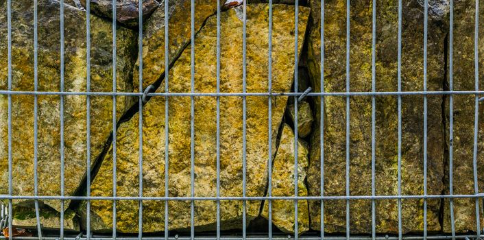 big stones behind a metal fence, beautiful garden decoration, natural background