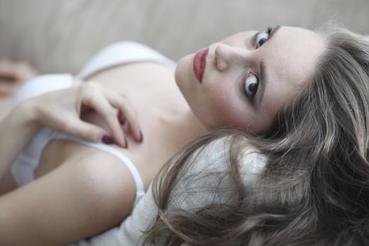 Portrait of beautiful young woman in lingerie on sofa