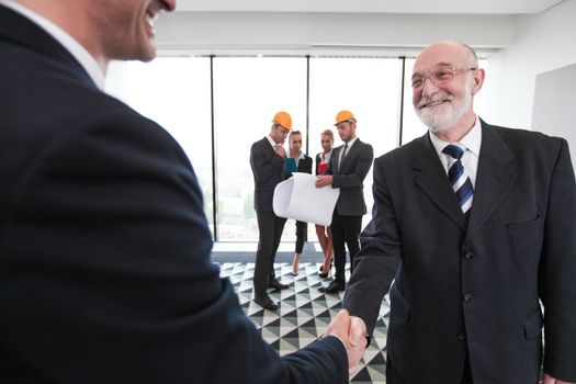Business people shaking hands at meeting of architects and investors in office