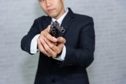 businessman with gun on gray background