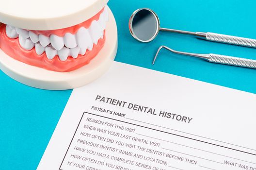 Dental history form with model tooth and dental instruments. Dental health and teeth care concept.