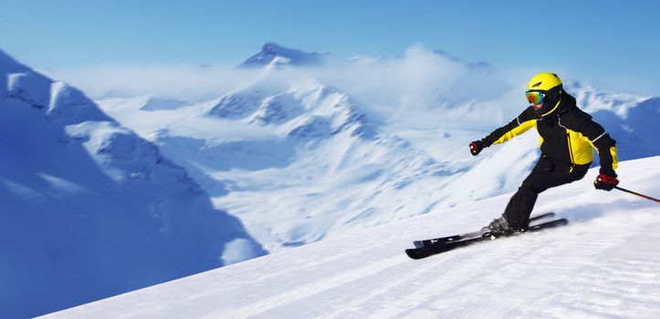 Professional alpine skier skiing downhill in high mountains of Alps