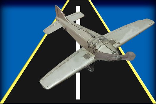 Image of a retro gray metal toy airplane with a runway in front of blue background.