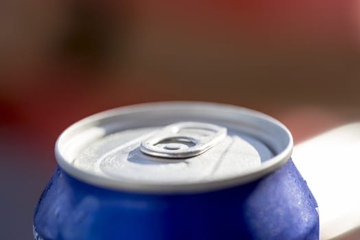 Close-up view on the top of a closed blue can drink with condensation.