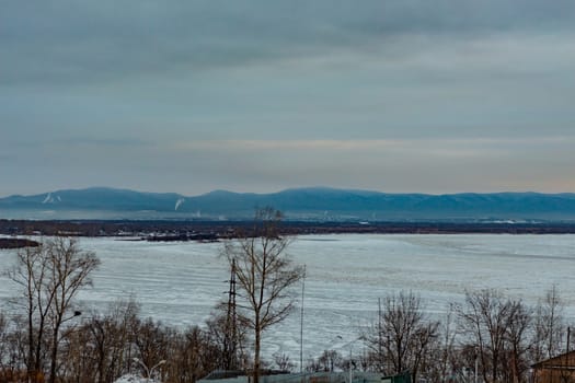 Morning view of the city of Khabarovsk in winter. Urban landscape. Frozen river. Dawn.
