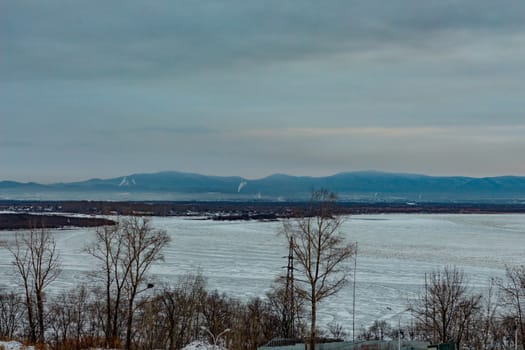 Morning view of the city of Khabarovsk in winter. Urban landscape. Frozen river. Dawn.