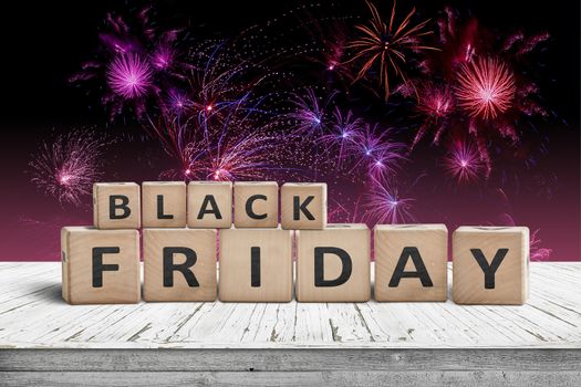 Black friday sign on a wooden table with fireworks in the background on the annual November 29th event