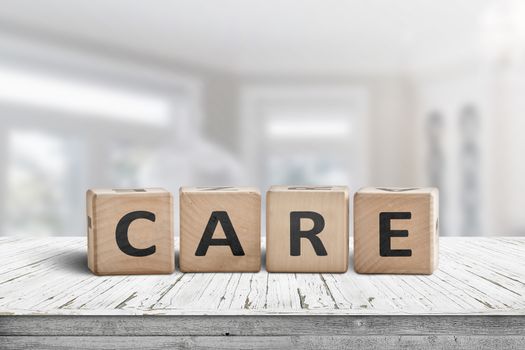 Care sign on a white table in a bright room with a blurry background