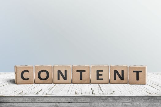 Content sign made of wood on an old table with a blue wall in the background