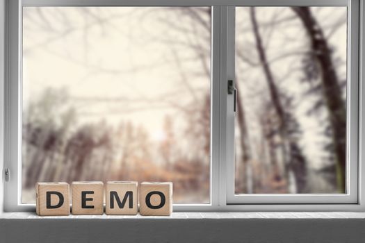 Demo sign in a window with a view to a forest in the morning