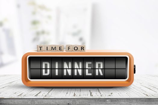 Time for dinner message on a wooden table with a retro alarm clock